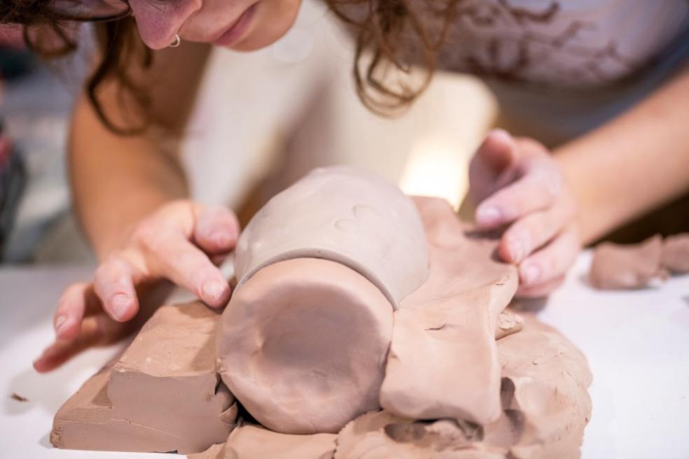 A photo of a student creating a mold for a ceramic mug.