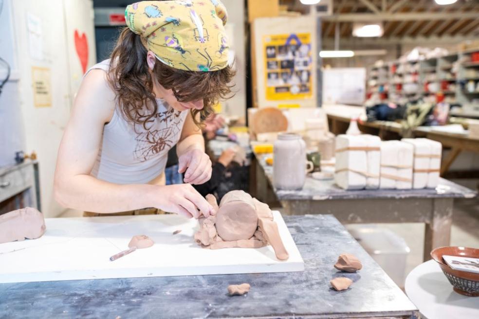 A photo of a student creating a mold for a ceramic mug.