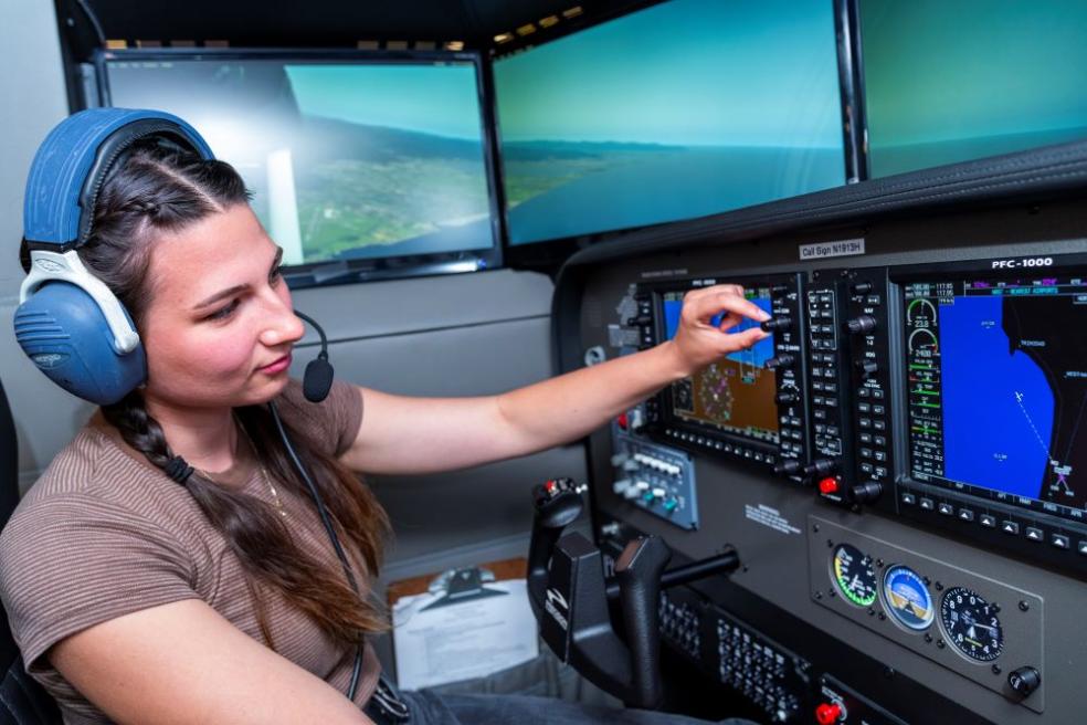 A photo of a student in the Library's newest flight simulator. 