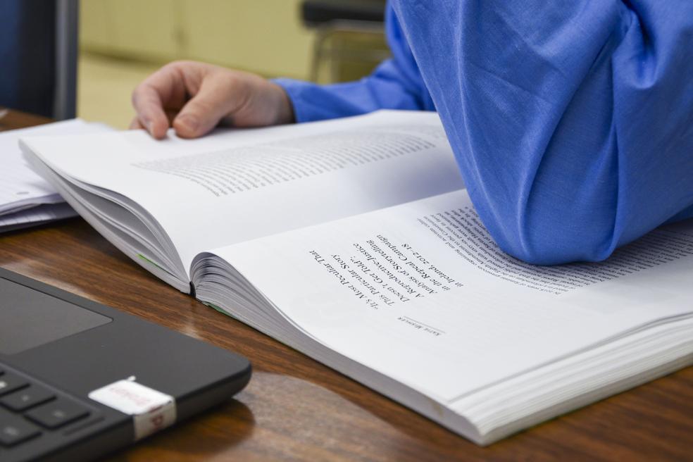 student reading from book
