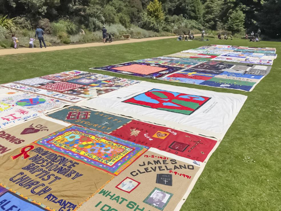 a colorful quit with red, white, yellow  and more panels laid out on a field