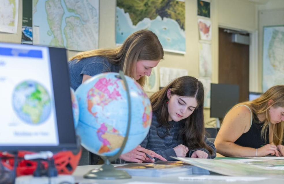 A photo of Geography Lecturer Jessica Janecek helping a student in class. 