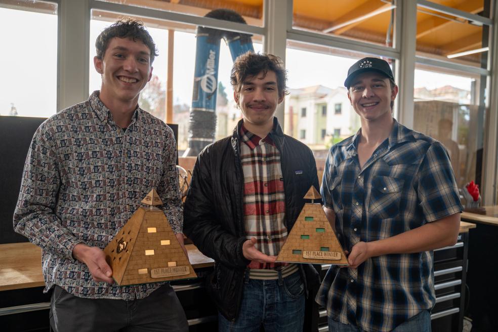 Members of team Trifecta showcasing the "Pyramid of Business & Economics" first place trophy.