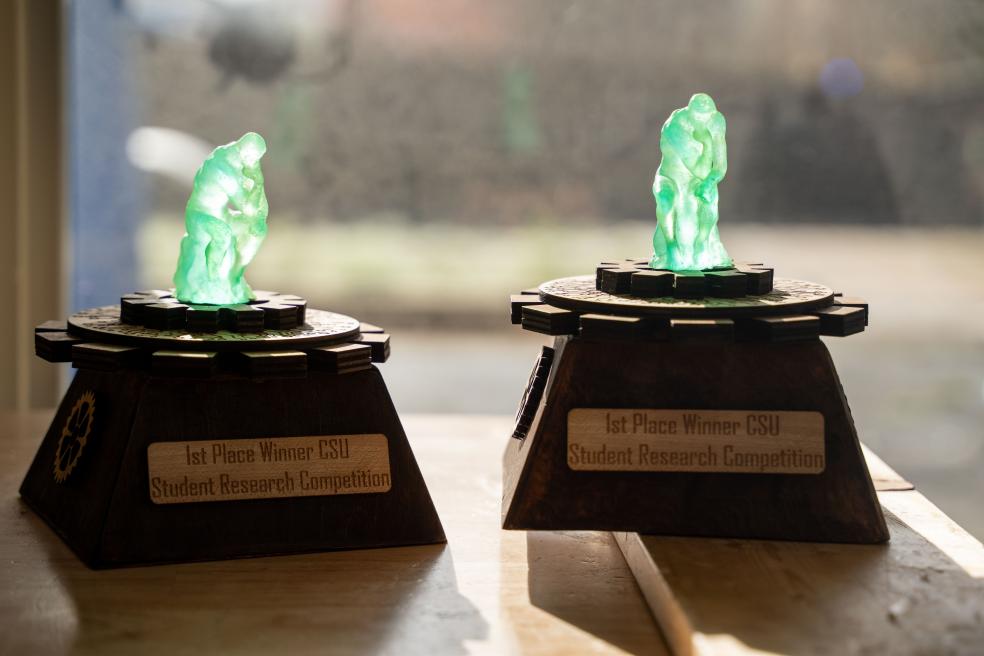 The Engineering and Computer Science trophies feature thinker gears, which serve as a platform for the Atlas stautues.