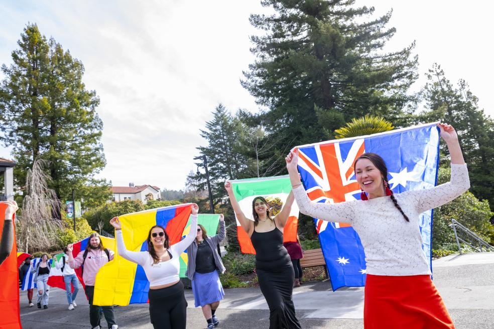 Members of the campus community carrying flags from different nations as part of the IEW's flag parade. 