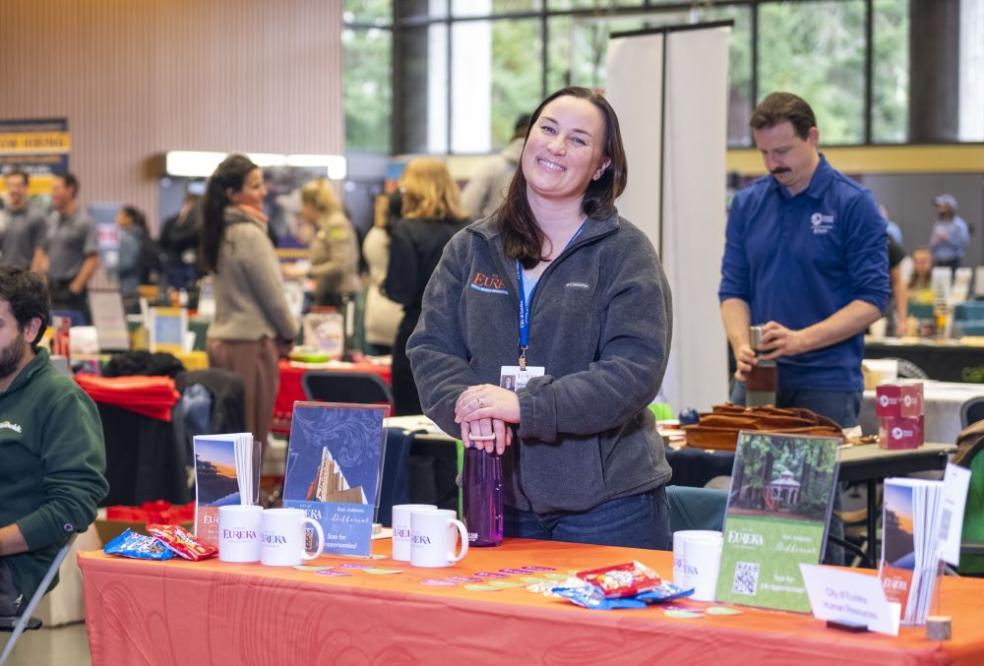 A recruiter from the City of Eureka in front of their table with information about working for the city of Eureka during last year's Career Expo & Volunteer Fair. 