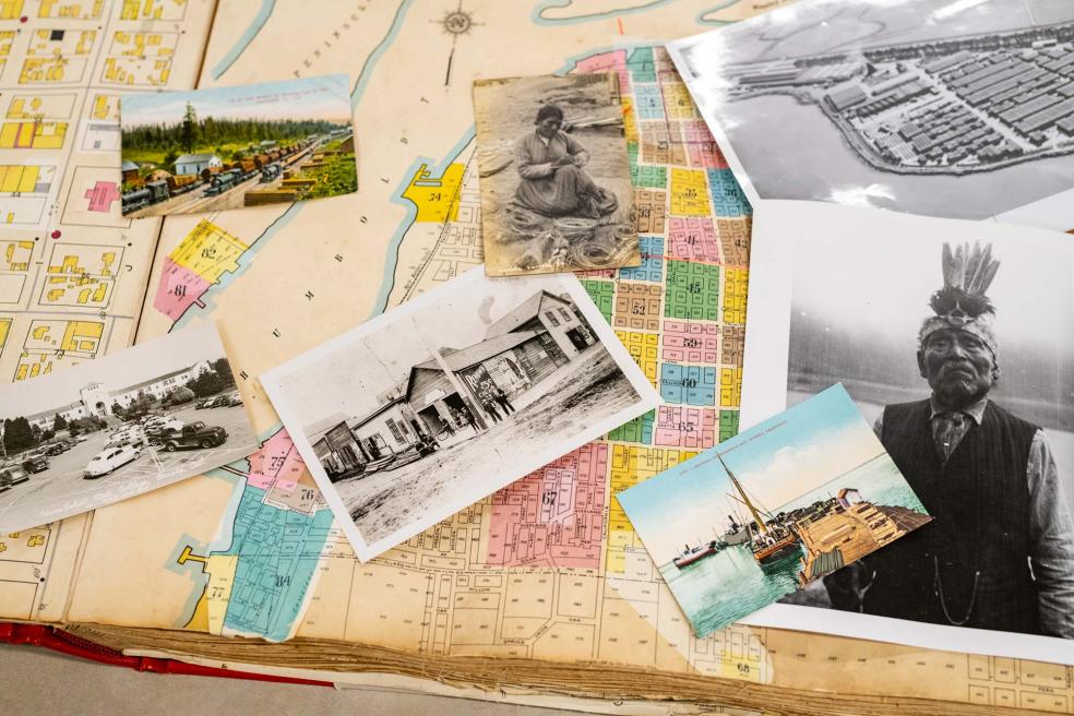 old photos, including a black and white photo of an Indigenous man, lay across an aging map of Humboldt County. 