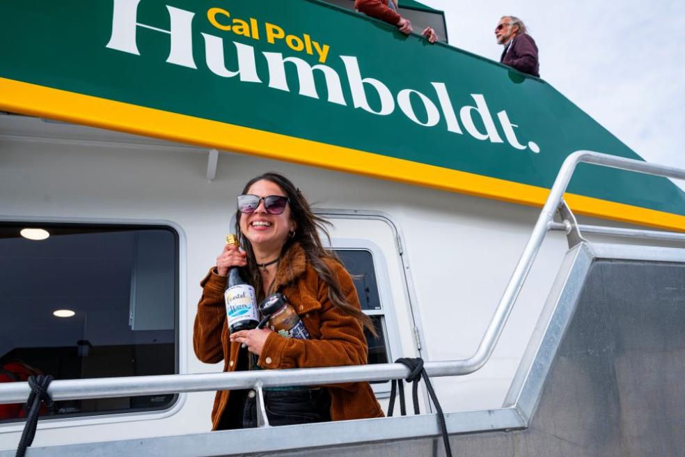 A photo of Jonae Calderon, a college analyst from the College of Natural Resources &amp; Sciences at the University, who christened the R/V North Wind, holding a champagne bottle.