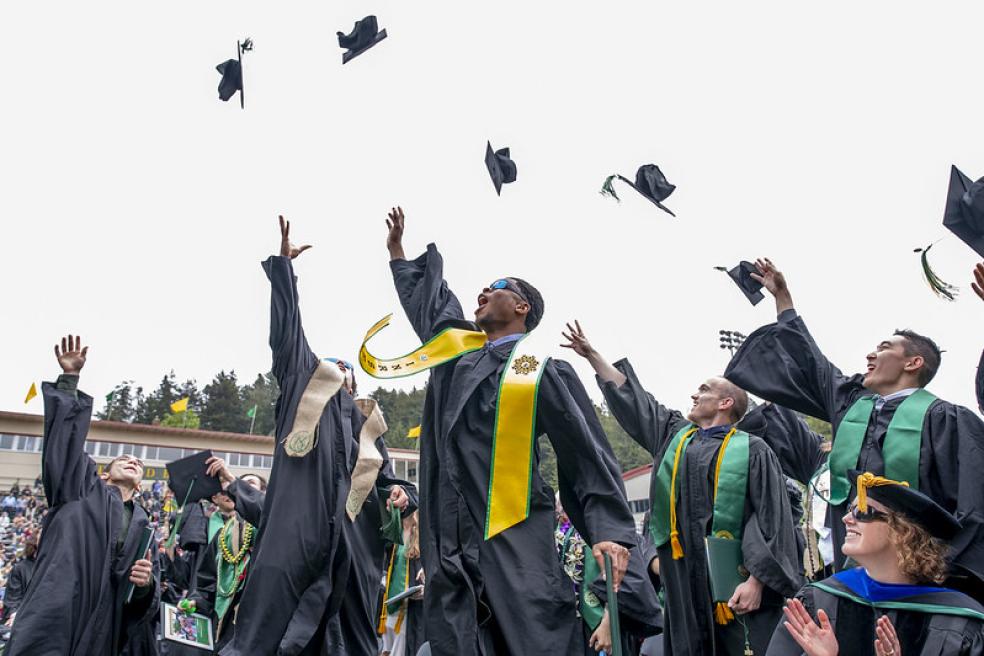 A photo of graduates throwing their caps during Spring Commencement in the Redwood Bowl.