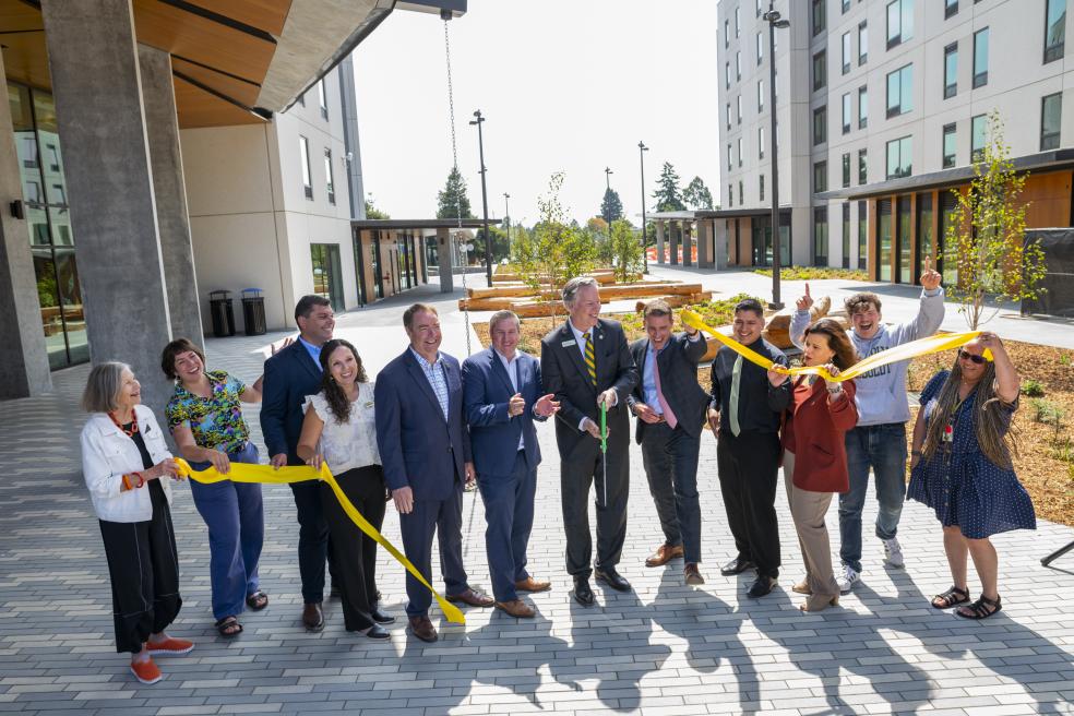 A photo (from left to right) of Alex Stillman, Kassidy Banducci, Mike Fisher, Damon Connolly, Chris Rogers, President Spagna (scissors), Mike McGuire, Eduardo Cruz, Chrissy Holliday, Cedrik von Briel, Donyet King cutting the ribbon at the Hinarr Hu Moulik student housing complex.