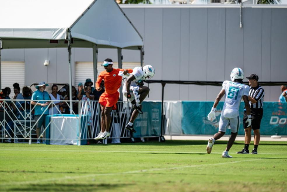 A photo of Robert Prince and a Miami Dolphins player jumping in celebration.