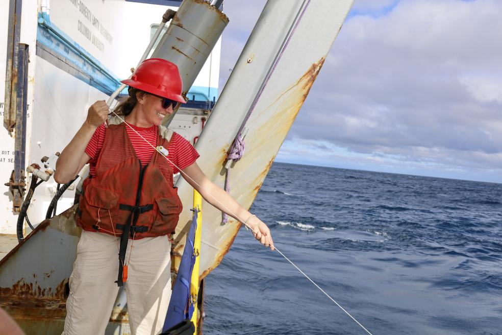 Claire Till holding a line off the side of a ship