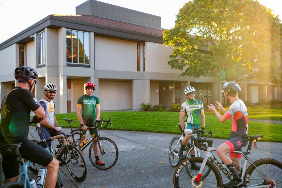A photo of the cyclists on their bicycles near the Library. 
