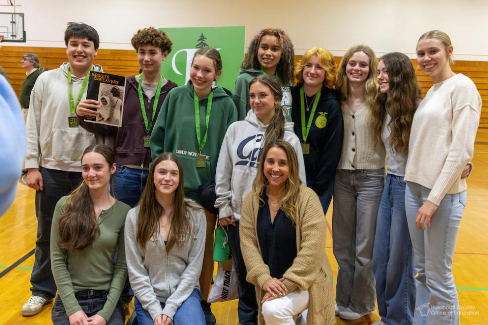 A group of students standing side by side smiling 