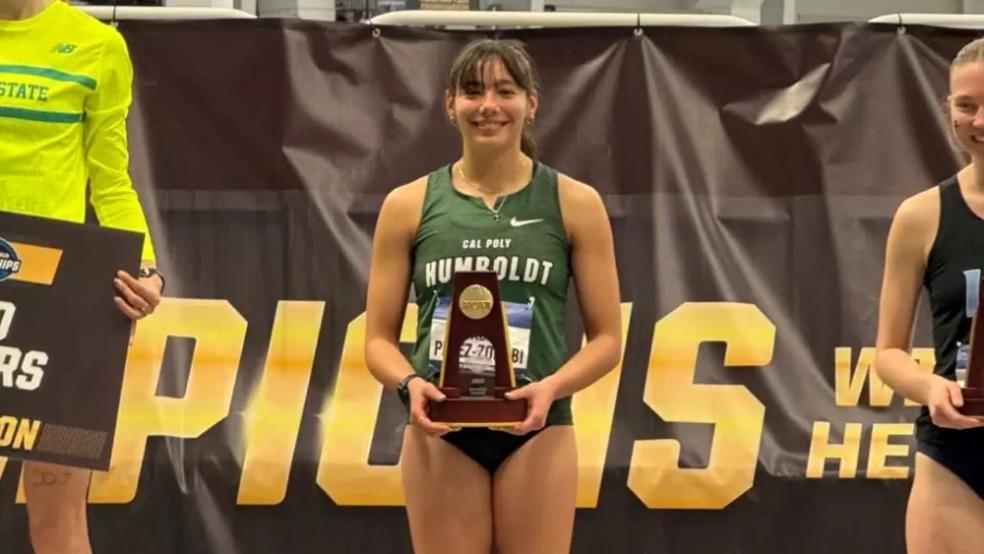 A photo of Isabel Perez-Zoghbi holding an NCAA honors trophy. 