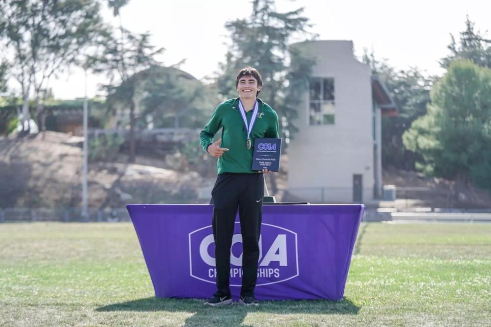 Pole vaulter Michael Payan stands proudly with "Field Athlete of the Meet" plaque. 