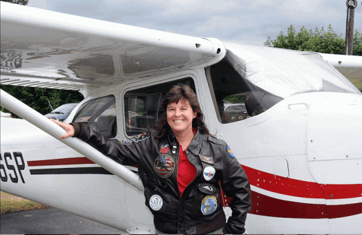 Meg Godlewski standing in front of a small plane.