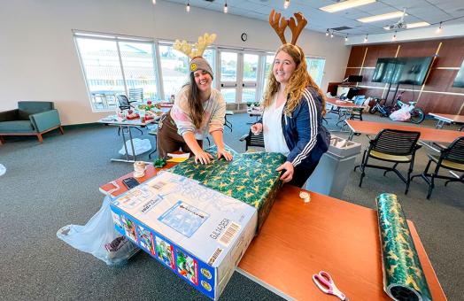 Volunteers wrap gifts for local children. 