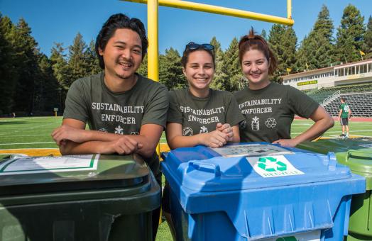 A photo of students and recycling bins at a campus event.