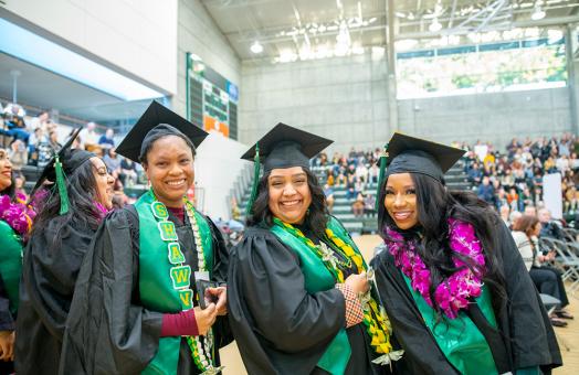 A photo of three Cal Poly Humboldt graduates at the fall commencement ceremony in 2022. 