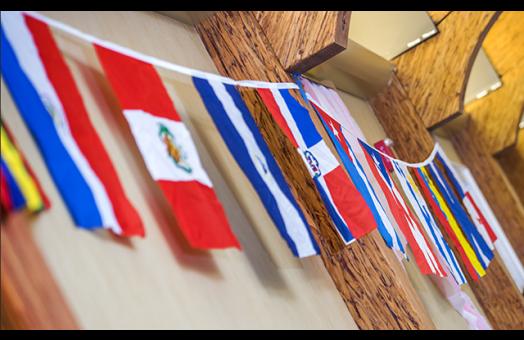 A photo of flags from different countries hanging on a wall