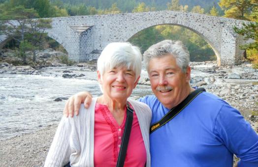 Jack and Diana McGurk standing in front of a bridge, next to a river