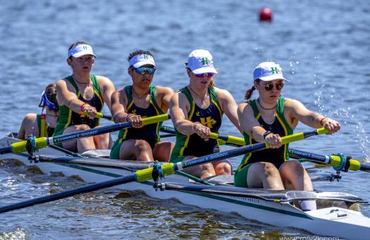 four member's of women's crew rowing in the water
