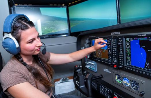 A photo of a student in the Library's newest flight simulator. 