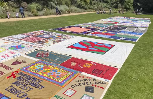 a colorful quit with red, white, yellow  and more panels laid out on a field
