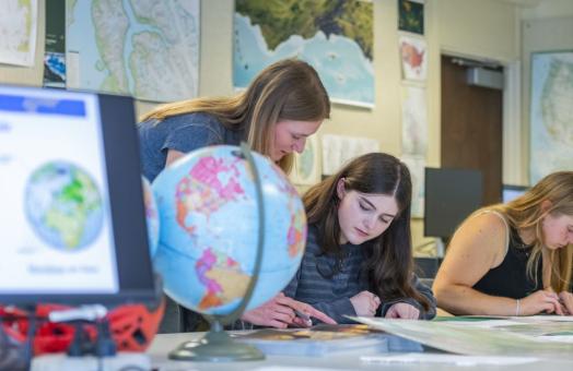 A photo of Geography Lecturer Jessica Janecek helping a student in class. 