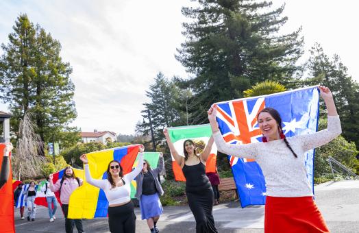 Members of the campus community carrying flags from different nations as part of the IEW's flag parade. 
