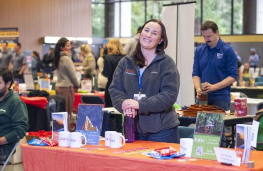 A recruiter from the City of Eureka in front of their table with information about working for the city of Eureka during last year's Career Expo & Volunteer Fair. 