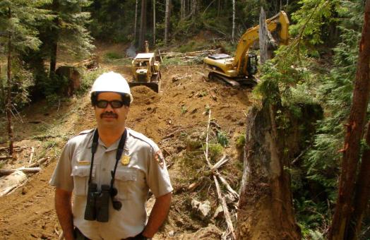 A photo of Leonel Arguello in front of active restoration efforts in Larry Dam Creek circa 2006. 