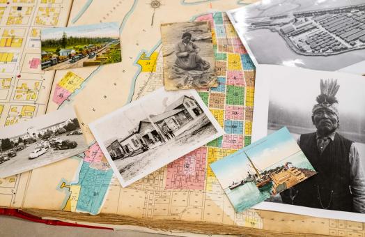 old photos, including a black and white photo of an Indigenous man, lay across an aging map of Humboldt County. 