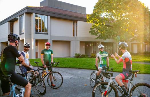 A photo of the cyclists on their bicycles near the Library. 