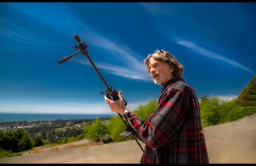 A photo of Ray Olson holding a tripod while filming an episode of Humboldt Outdoors.