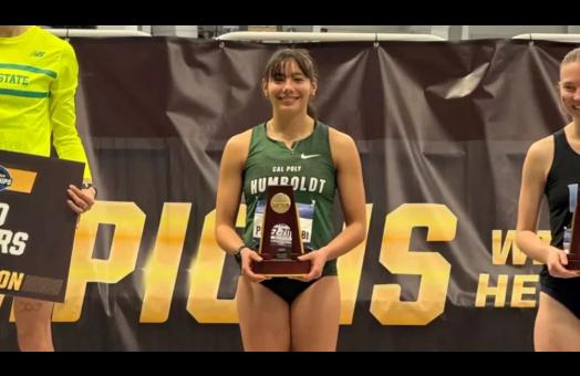 A photo of Isabel Perez-Zoghbi holding an NCAA honors trophy. 