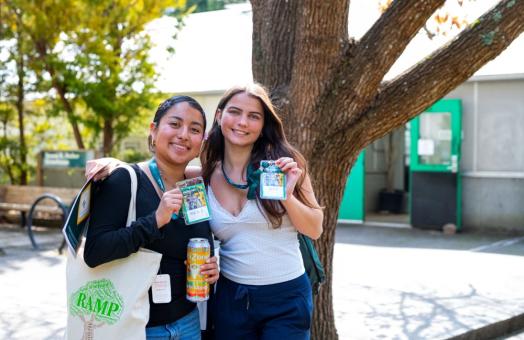 A photo of two students posing for a photo while holding up their Spring Preview name tags. 