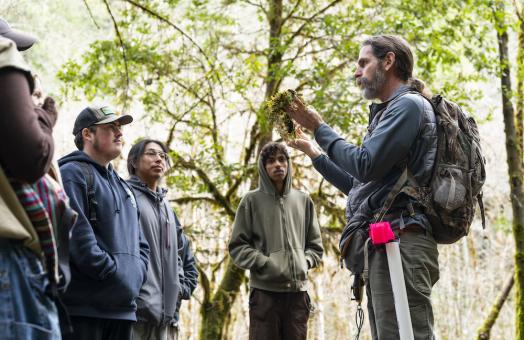 professor showing students a plant at a watershed