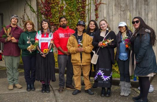 A group of students and staff standing side by side and smiling at the camera. 
