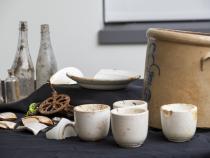 Items including cups, plates, a pickling pot, and condiment bottles that were found during excavations of one of the town’s cookhouses.