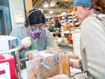 A photo of students working on creating ceramic mugs.