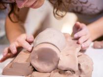 A photo of a student creating a mold for a ceramic mug.