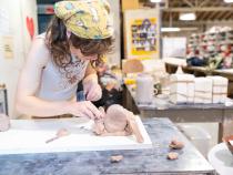 A photo of a student creating a mold for a ceramic mug.